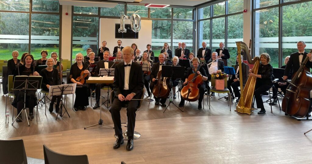 Robin Moore and the orchestra in formal dress for a concert in October 2023